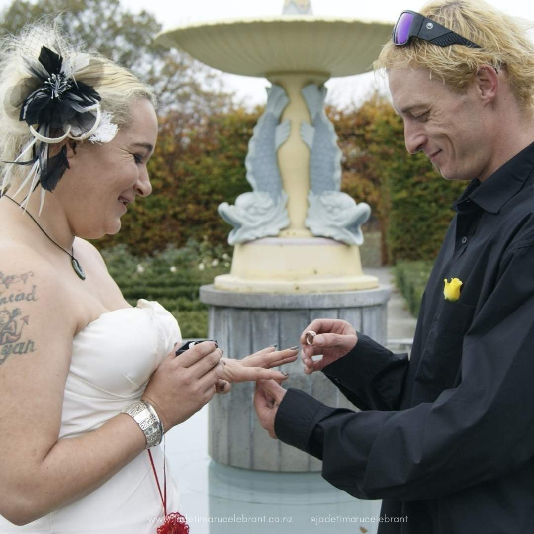 Registry wedding couple with groom placing ring on his brides hand at Timaru Botanic Gardens.