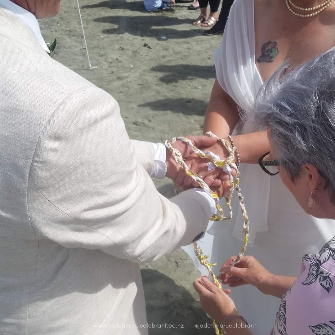 Jade Whaley Timaru Celebrant doing a hand fasting with a wedding couple at Caroline bay in South Canterbury