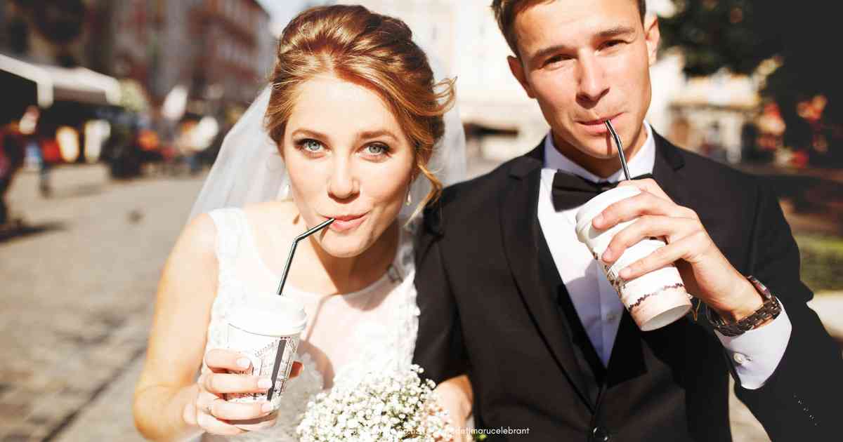 Bride on groom on their wedding day, holding a takeaway cup and drinking with a straw