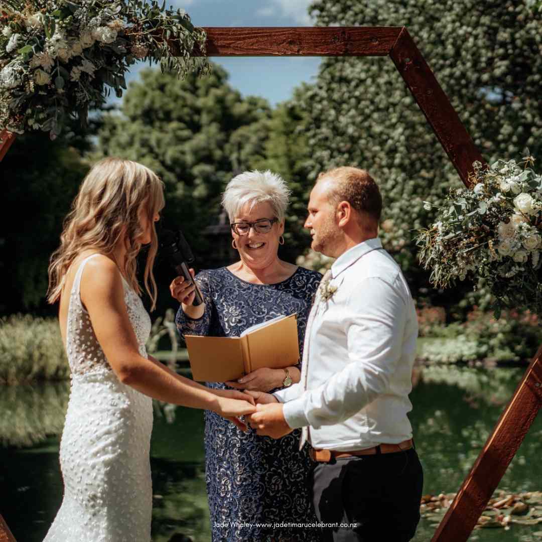 Jade Whaley Marriage celebrant holding microphone for brides vows at Trotts Gardens, Ashburton.