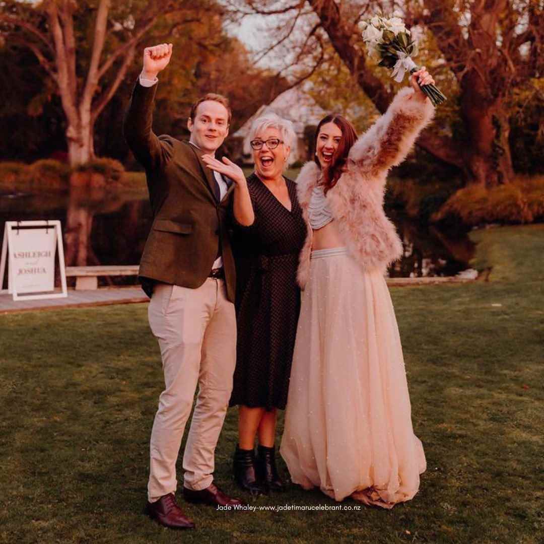 Wedding couple and Jade Whaley Timaru Celebrant with hands in air after their wedding ceremony at Stonebridge Wedding and Events, Geraldine, South Canterbury