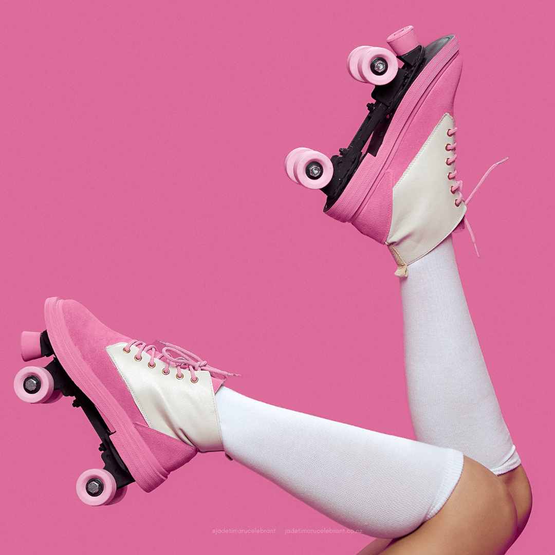 Legs in air with pink roller skates.